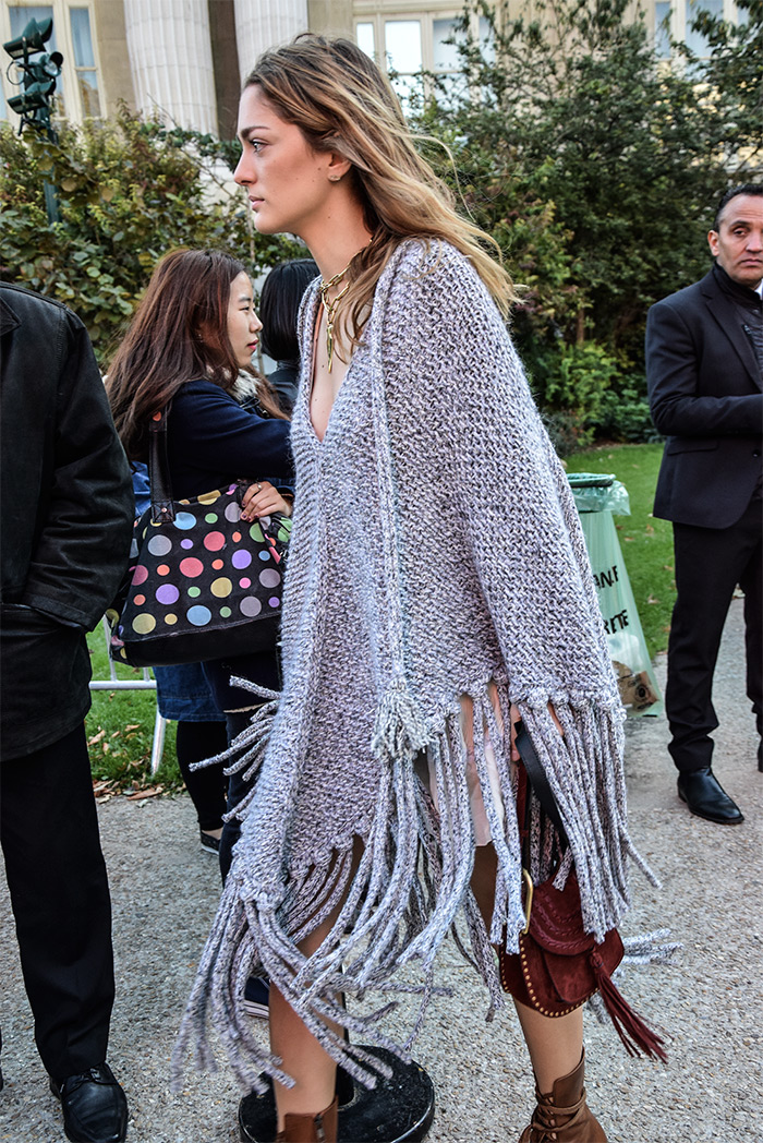 How to wear woven poncho, Sofia Sanchez de Batek wearing grey woven poncho, Paris Fashion Week street style fashion by PeopleandStyles.com