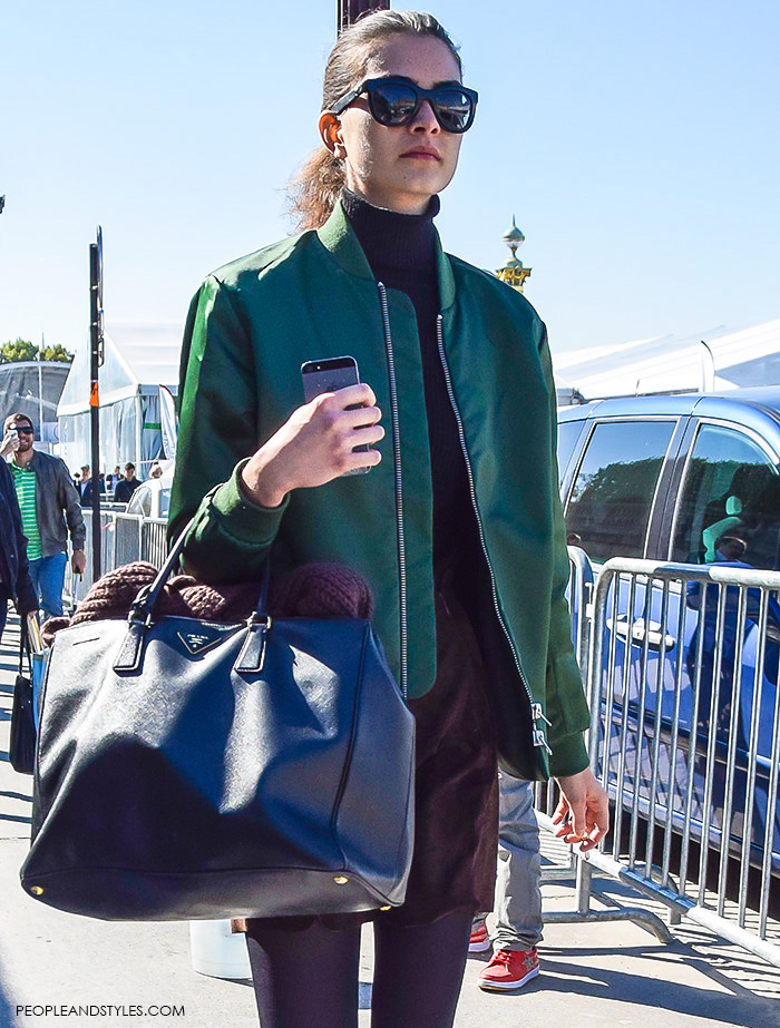How to wear green bomber jacket, turtleneck, brown mini skirt, Prada tote bag, Celine sunglasses and biker boots. Model off duty look, street style fashion Paris, what to wear now, girl with iPhone