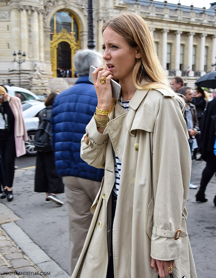 Jennifer Neyt wearing dark color wide leg jeans, stripe sweater, trench coat and mixing it with a lot of golden jewellery, street style look new Instagram